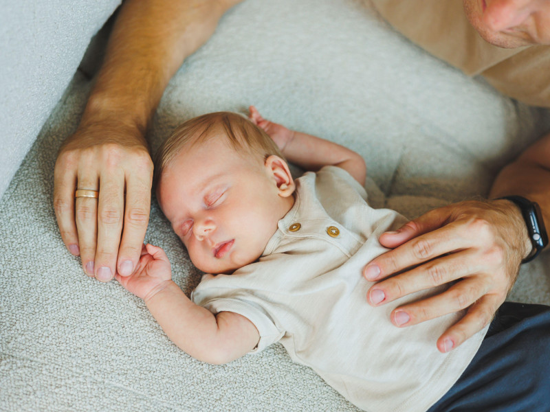 Las manos de una madre y un padre amorosos sostienen a un bebé recién nacido. La paternidad feliz y la alegría de ser padres