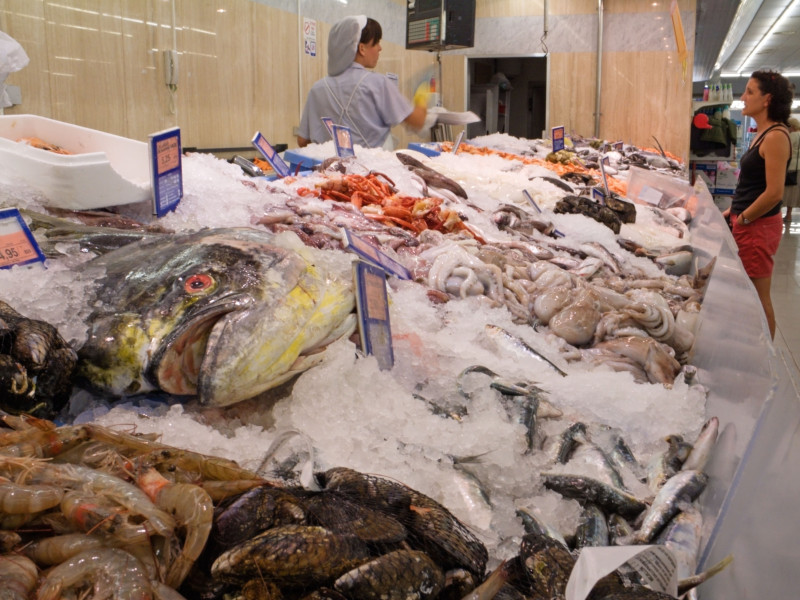 Selección de pescado fresco en exposición en un supermercado español, con un gran mahi-mahi, dorado o pez dorado en primer plano, España