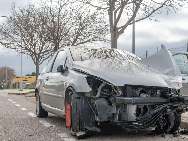 Un coche Peugeot abandonado y destrozado en un polígono industrial de la ciudad de Palma de Mallorca