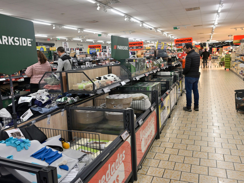 Gran pasillo central de un supermercado Lidl con artículos para el hogar en exposición y otras áreas a distancia