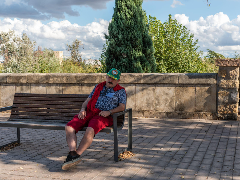 Un turista se echa una siesta rápida en un banco a la sombra junto al Alcázar de los Reyes Cristianos en Córdoba