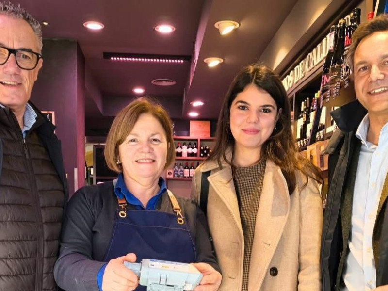 María Jesús Álvarez, de Productos Gorfolí, con el dispositivo en sus manos junto a representantes de la empresa creadora y de Raquel Ruiz, concejala de Comercio