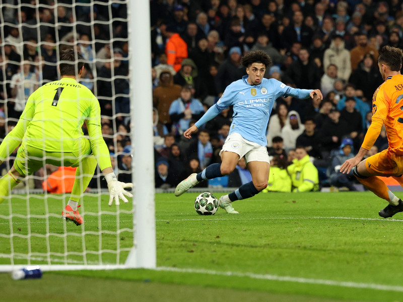 Rico Lewis (C) del Manchester City en acción contra Raúl Asencio (R) del Real Madrid durante el partido de ida de los play-offs de la fase eliminatoria de la UEFA Champions League entre el Manchester City y el Real Madrid, en Manchester, Gran Bretaña, el 11 de febrero de 2025