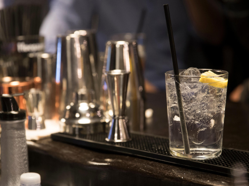 Primer plano de una barra de bar desde el punto de vista del barman. Un gin tonic está listo para servir.