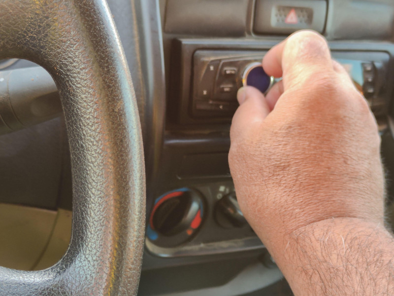 Hombre conduciendo usando una radio de coche