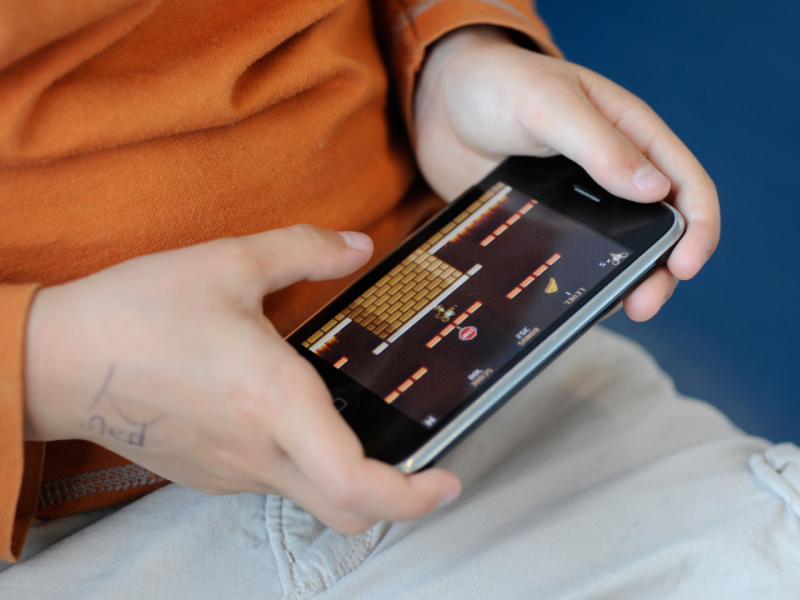 Niño jugando a un videojuego en un teléfono móvil