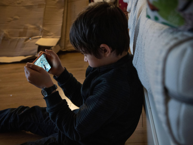 Niño viendo un vídeo en el teléfono a oscuras