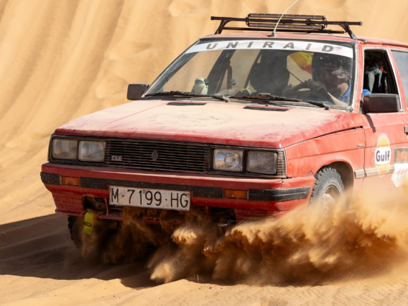 Un coche conduce por una duna marroquí durante el UniRaid