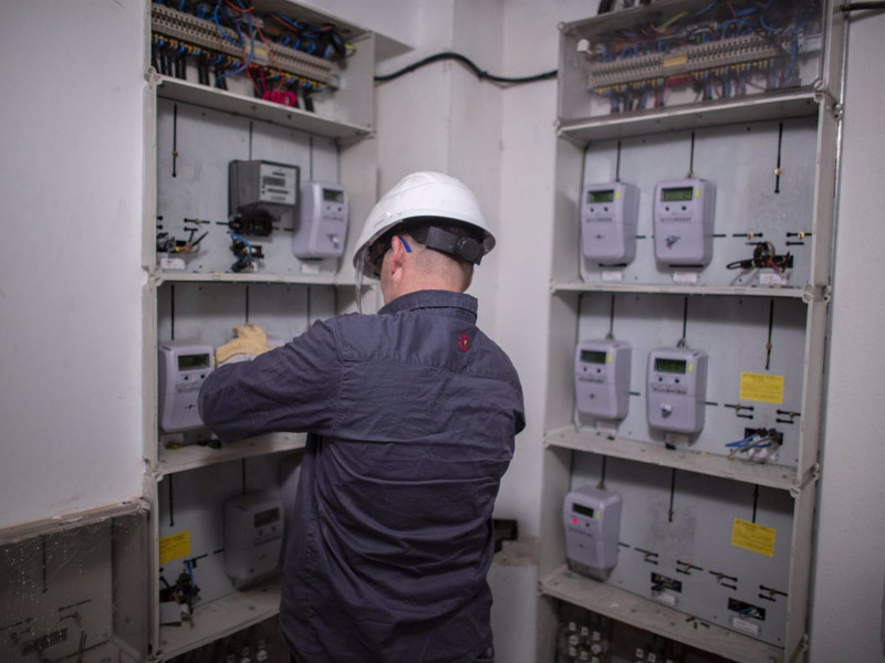 Un trabajador desmantela enganches irregulares a la red eléctrica.