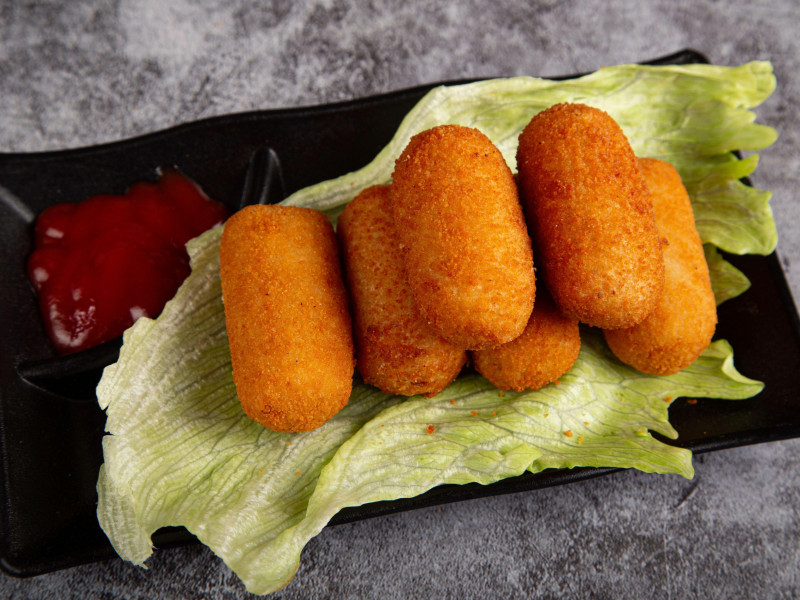 Croquetas caseras tradicionales españolas o croquetas en plato sobre una hoja de lechuga