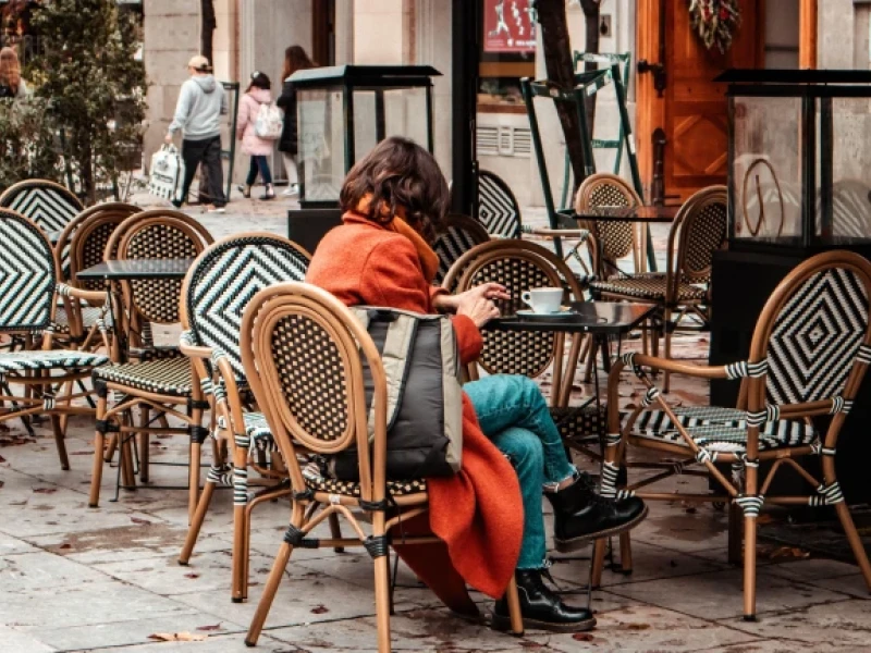 Una acogedora terraza de cafetería o restaurante con mesas y sillas en un día de otoño.