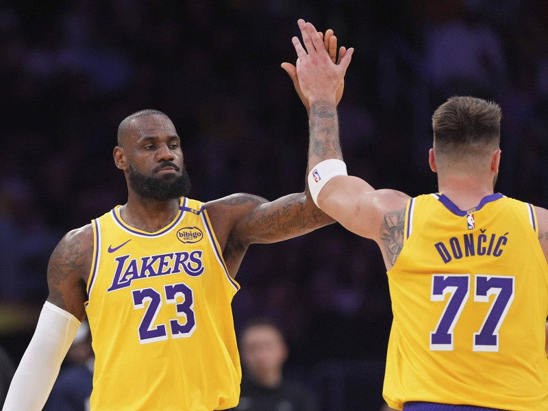 Los Angeles Lakers forward LeBron James, left, is congratulated by guard Luka Doncic after he scored during the first half of an NBA basketball game against the Minnesota Timberwolves, Thursday, Feb. 27, 2025, in Los Angeles. (AP Photo/Mark J. Terrill)