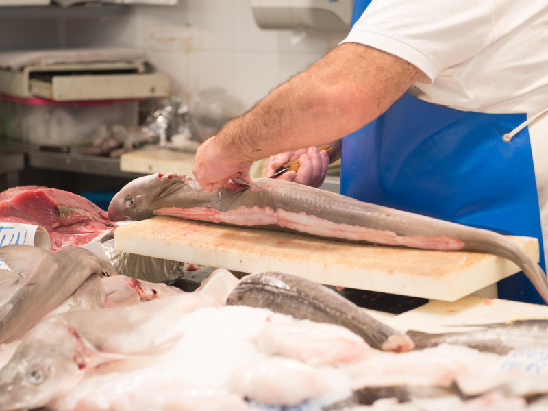 Pescadero experto fileteando pescado según los requisitos del cliente en uno de los mercados locales