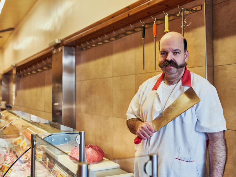 Retrato, hombre y carnicero en tienda con cuchillo para cortar alimentos orgánicos en una pequeña empresa emergente en España