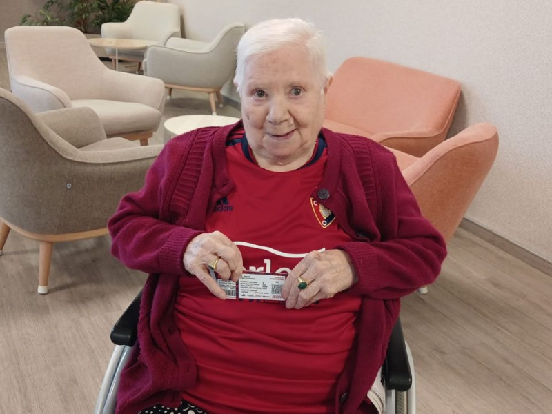 María Jesús posa con los tres carnets de Osasuna que guarda en su cartera.