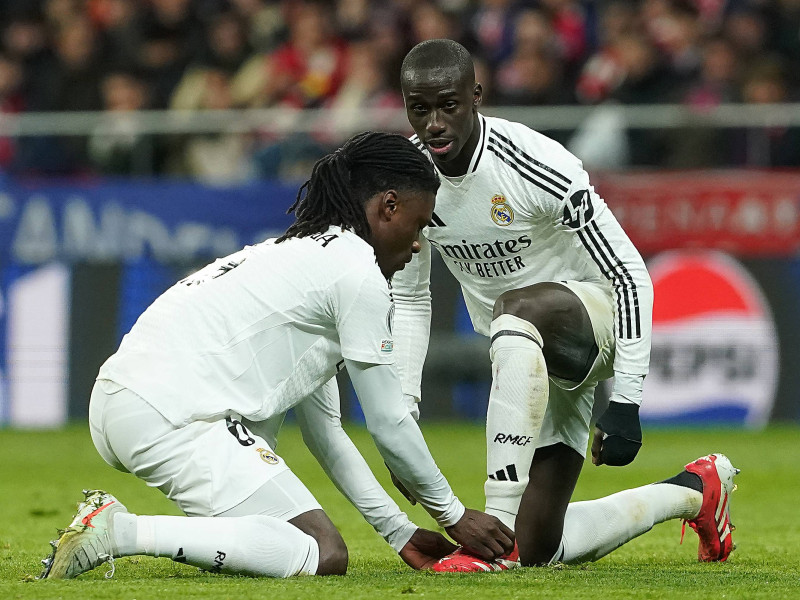 Camavinga ayuda a Mendy a atarse las botas durante el partido de este miércoles en el Metropolitano.