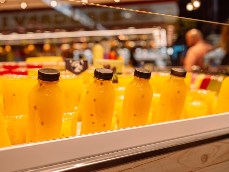 Frutas y jugos saludables en botellas con hielo en el mostrador del mercado.