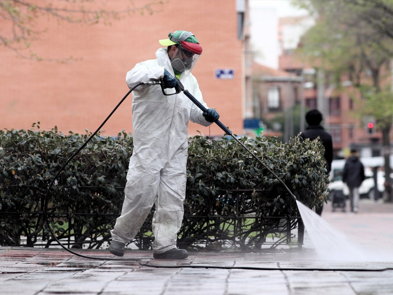 Operarios de limpieza desinfectan las calles durante el tercer día laborable desde que se decretó el estado de alarma a consecuencia del coronavirus, en Madrid