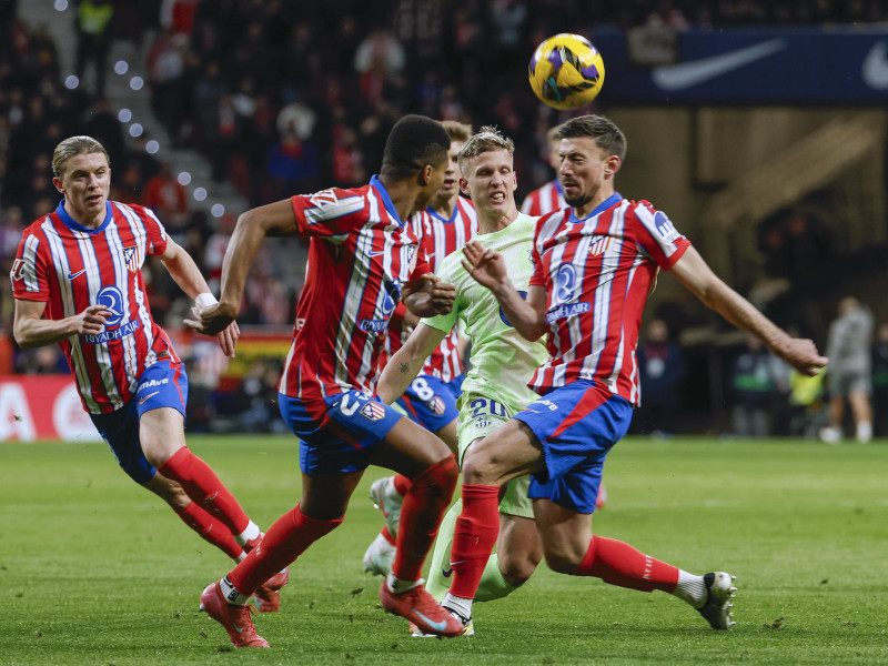 El centrocampista del FC Barcelona, Dani Olmo (2d), disputa el balón ante los defensores del Atlético de Madrid durante el encuentro correspondiente a la jornada 28 de Laliga EA Sports que disputan hoy domingo Atlético de Madrid y FC Barcelona en el estadio Metropolitano, en Madrid.