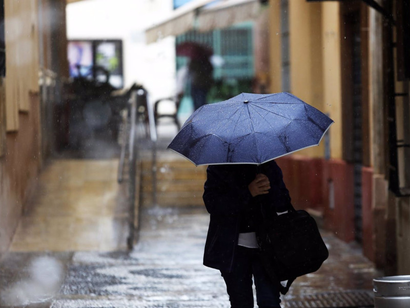 Una persona se protege de la lluvia de la borrasca