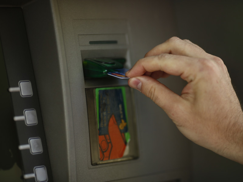 Un usuario de un banco introduce su tarjeta en el cajero
