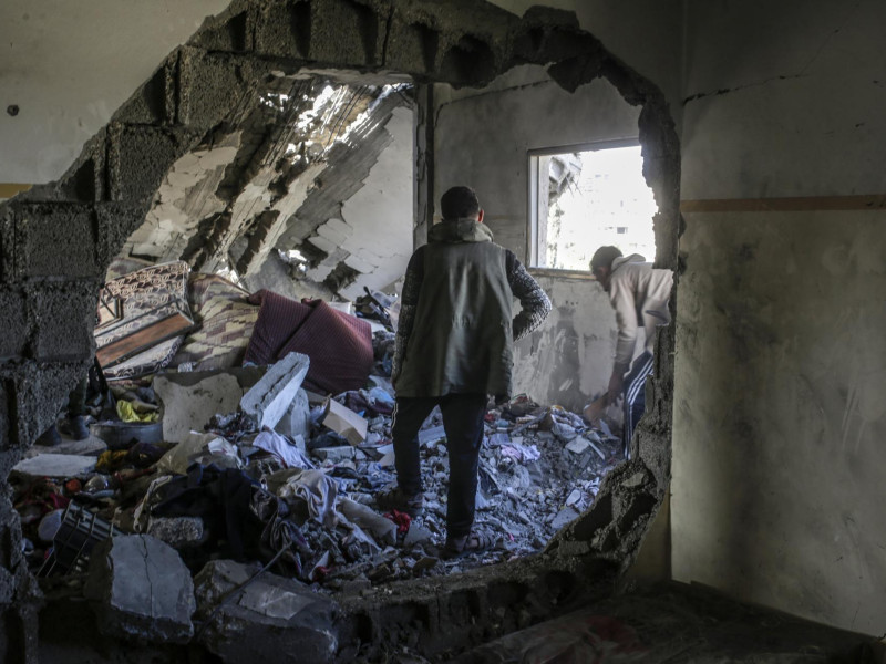 Dos palestinos inspeccionan un colegio devastado por el ataque de Israel