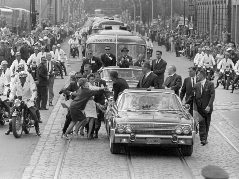 Foto de archivo tomada el 26 de junio de 1963 de un grupo de mujeres que rompen el cordón de seguridad y se acercan al coche en el que viaja el presidente estadounidense John F. Kennedy, durante la visita de éste a Berlín