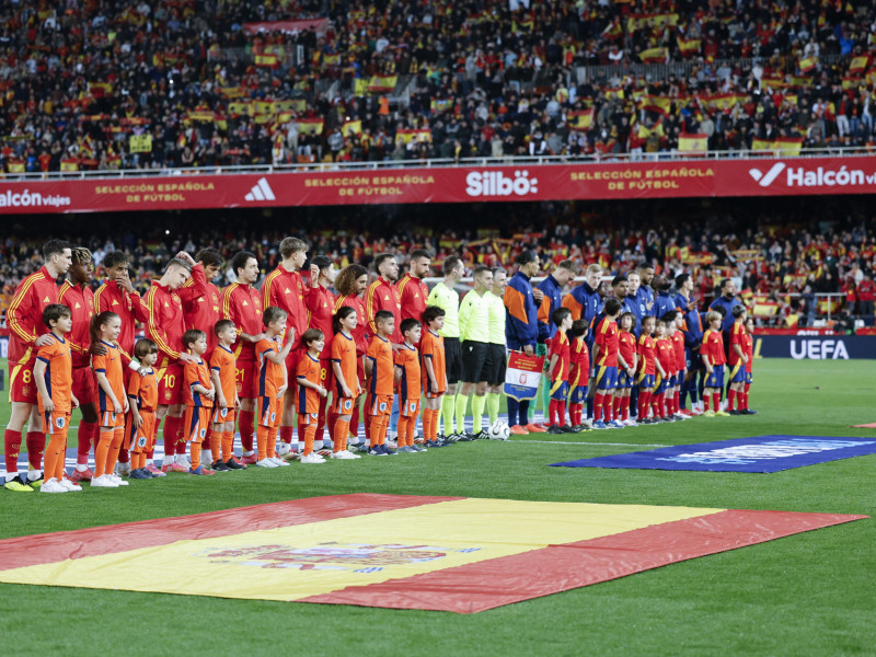 Los once titulares de las dos selecciones durante los himnos