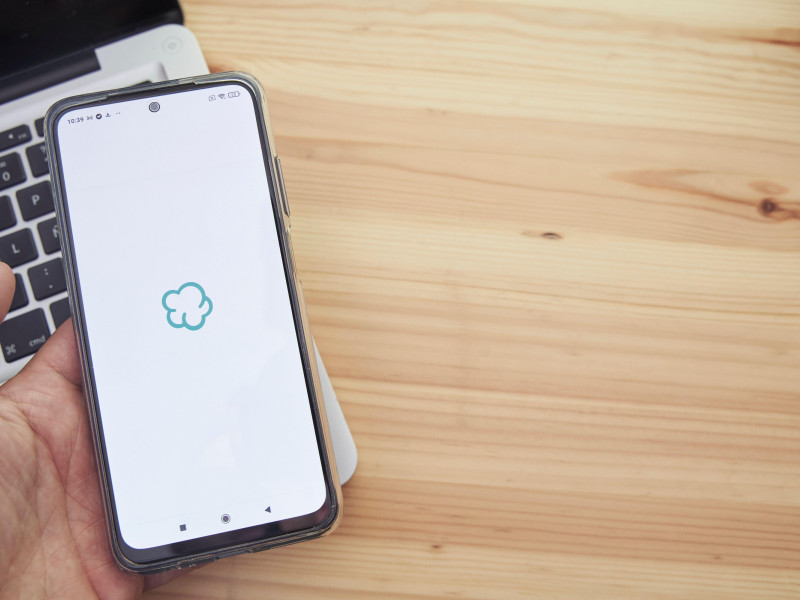 Manos sosteniendo un dispositivo móvil inteligente con el logotipo de la aplicación Wallapop de la empresa en la pantalla