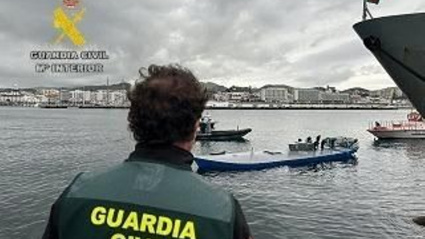 Un agente de la Guardia Civil observa una embarcación dedicada a transporte de drogas