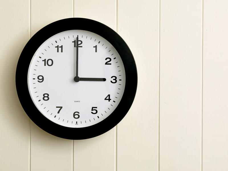 Reloj de pared que muestra la hora a las tres en punto