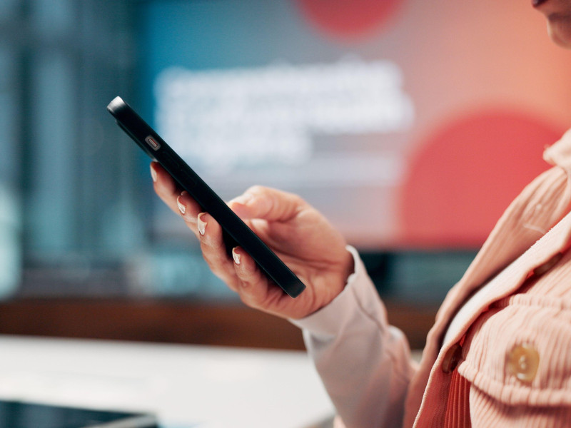 Negocios, manos y mujer en la oficina, teléfono inteligente y comunicación con redes sociales.