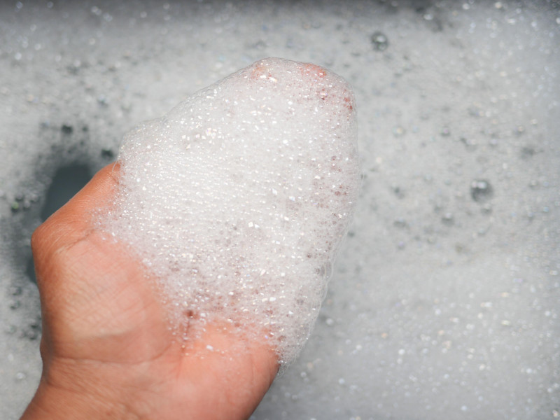 Mano cubierta de burbujas durante un minucioso proceso de lavado de manos.