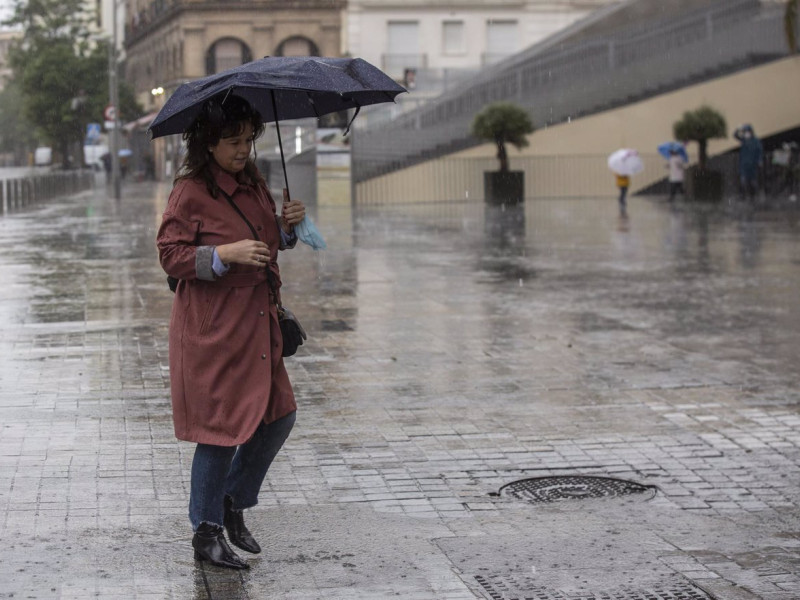 14/05/2020 Una mujer se resguarda de la lluvia bajo su paraguas durante la alerta amarilla por tormentas en Sevilla, (Andalucía, España), a 14 de mayo de 2020.SOCIEDAD María José López - Europa Press