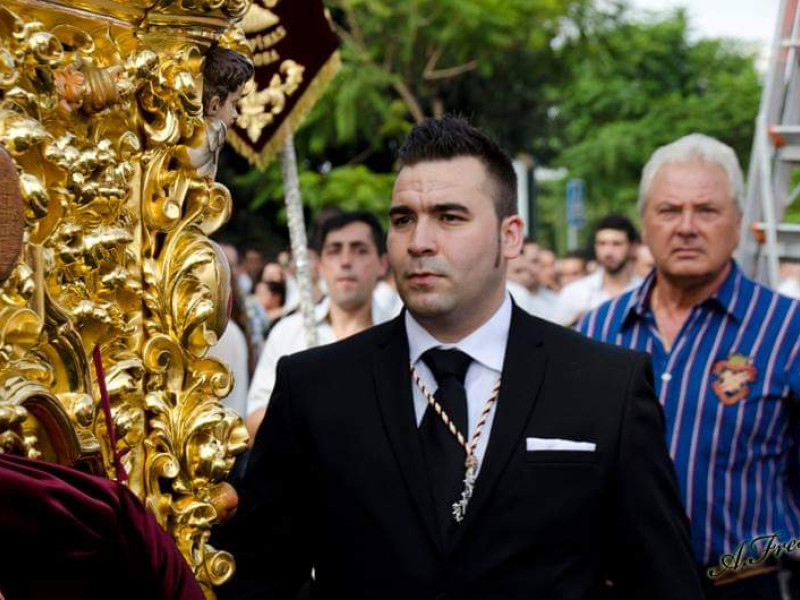 José Luis al fondo con camisa azul detrás de uno de los titulares