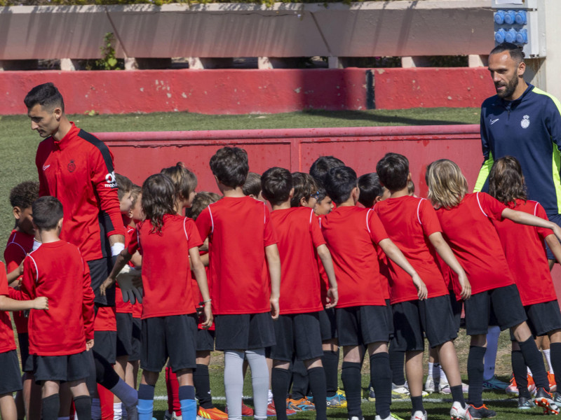 Vedat Muriqi (d), y Dominik Greif (i), del Mallorca, saludan a un grupo de niños en un entrenamiento a puertas abiertas