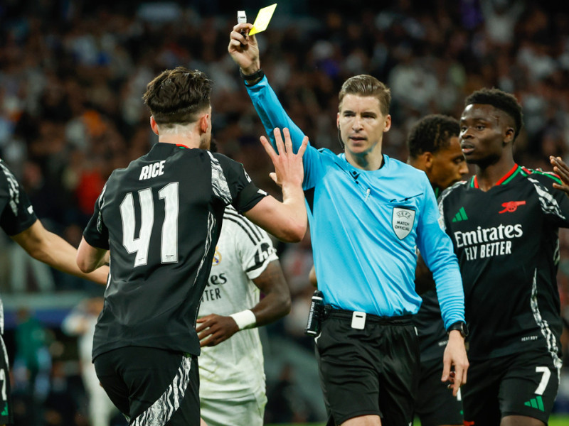 El árbitro Francois Letexier saca tarjeta amarilla a Declan Rice por un penalti que después fue anulado durante el partido de vuelta de cuartos de final de la Liga de Campeones que Real Madrid y Arsenal juegan hoy miércoles en el estadio Santiago Bernabéu