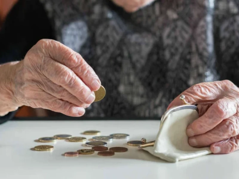 Persona anciana cuenta monedas.