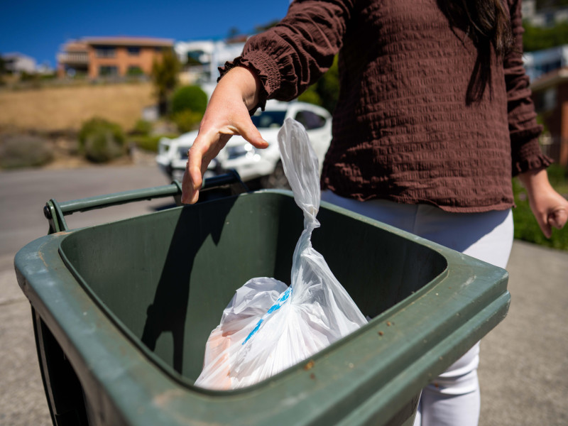 Mujer tirando algo a la basura