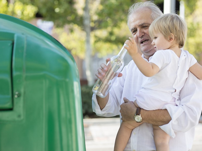 Un abuelo recicla junto a su nieta