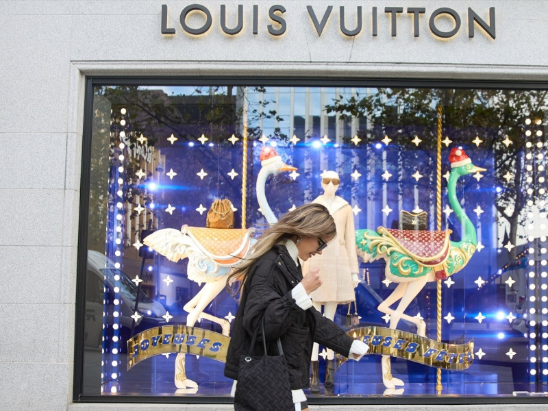 Una mujer camina frente a una tienda de Louis Vuitton en Madrid