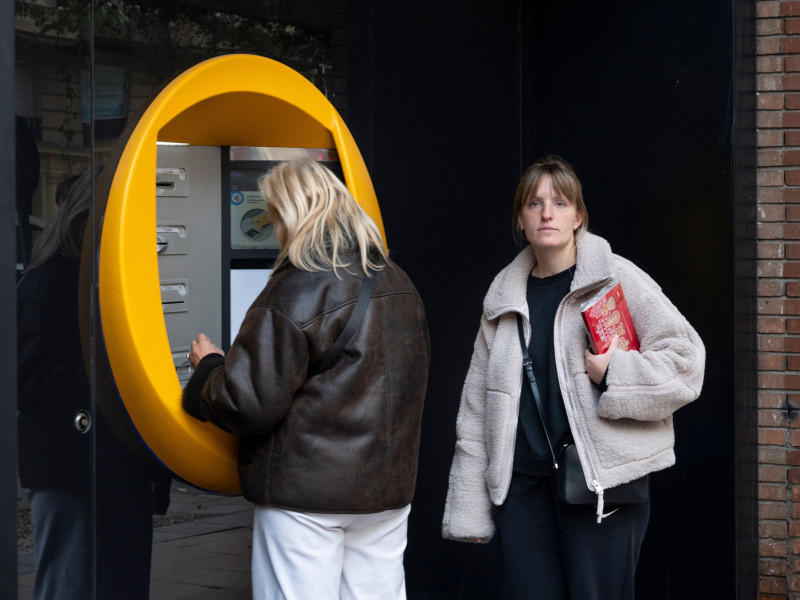 Los clientes retiran dinero de un cajero automático en la sucursal de CaixaBank, la caja de ahorros más grande de España.