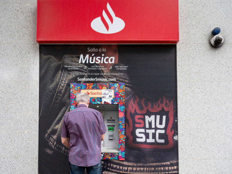 Un cliente utiliza el cajero automático de una sucursal de Santander, el banco comercial multinacional español y compañía de servicios financieros, en España