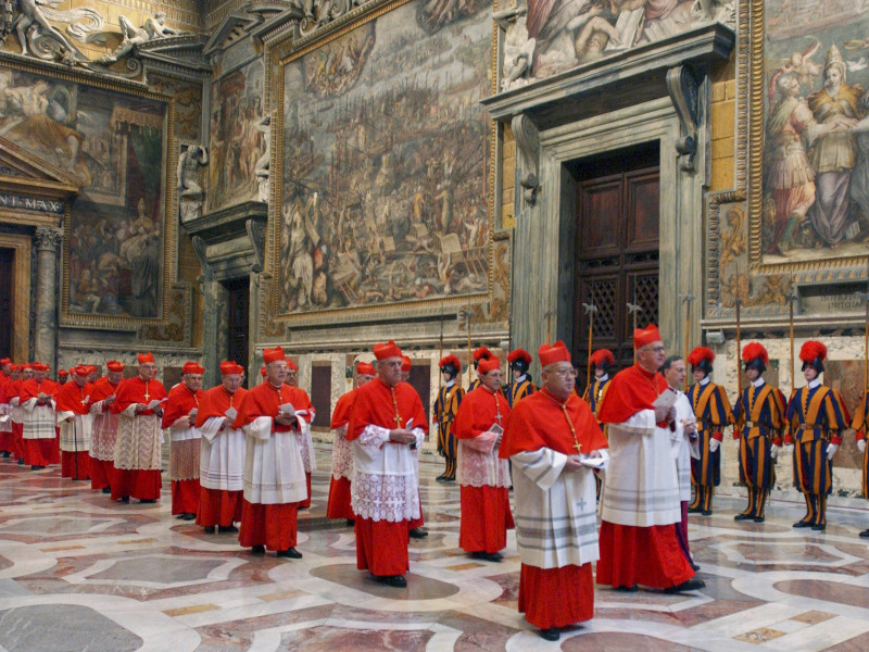 Los cardenales caminan en procesión hacia la Capilla Sixtina