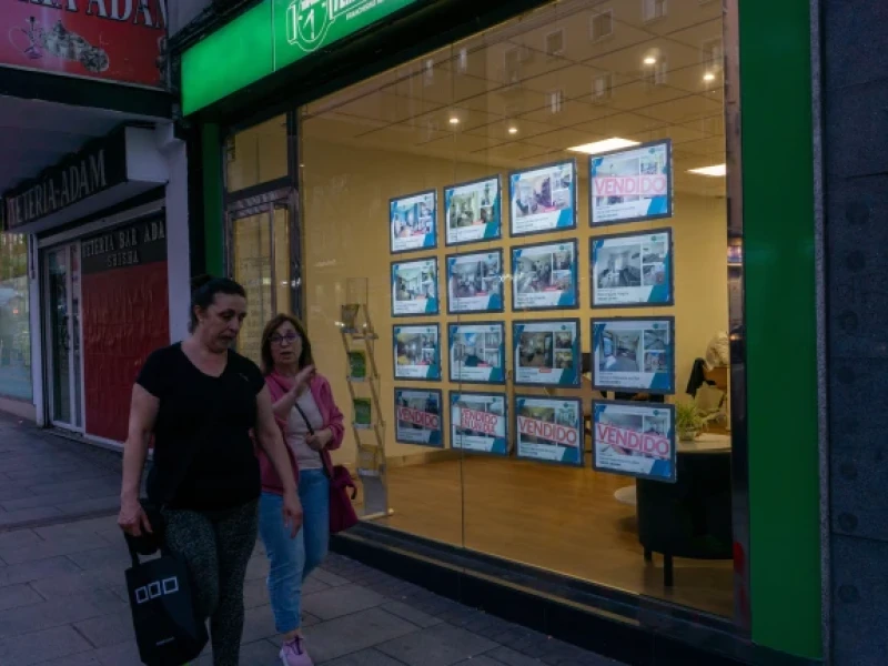 Gente paseando delante de una inmobiliaria