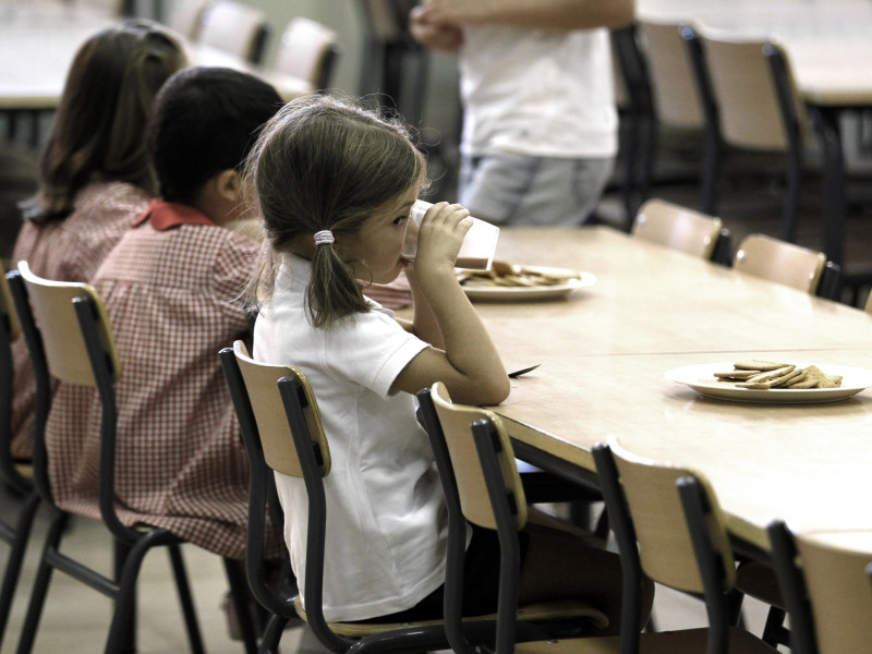 Una niña, en el comedor escolar