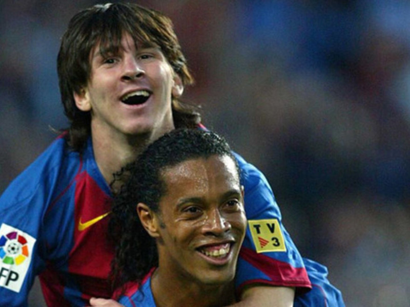 Leo Messi celebra con Ronaldinho su primer gol oficial con el Barcelona