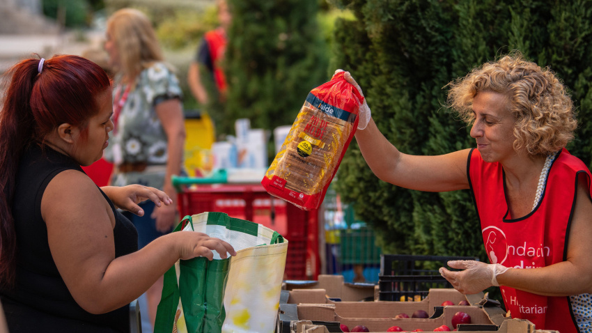 Una mujer recibe pan donado por la Fundación Madrina