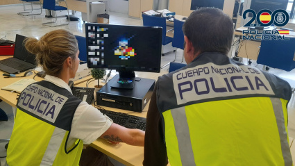 Agentes de la Policía Nacional delante de un ordenador