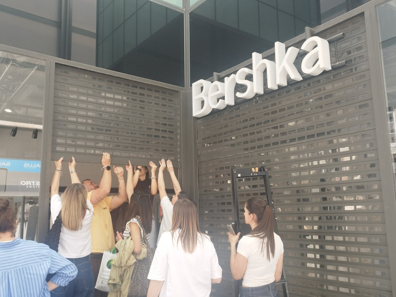 Bajando manualmente la persiana del Bershka de la Plaza de Lugo durante el apagón